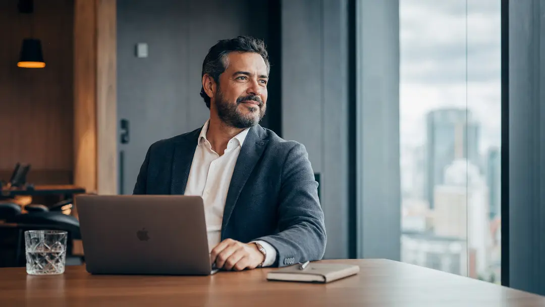 Líder contábil brasileiro em escritório moderno exercendo autonomia e alta performance em times remotos